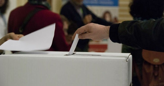 Un ciutadà deposita el seu vot en la Escola Infant Jesús de Barcelona.
