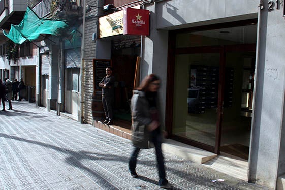 Una dona creua pel davant de la porta d'entrada on residia el matrimoni assassinat a Tunísia.