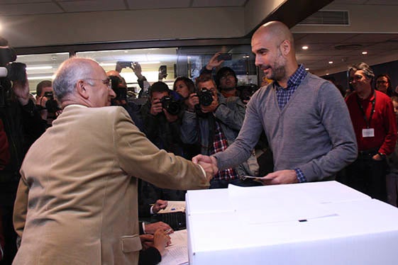L'entrenador Pep Guardiola saluda als voluntaris instants abans de votar en el procés del nou 9-N al CIC de Barcelona.
