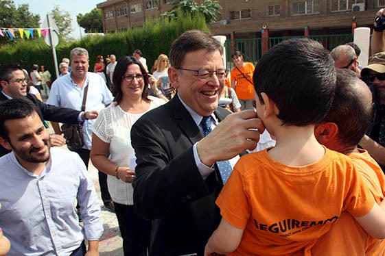 Ximo Puig, saluda un nen a l'entrada del Col·legi Ciutat de Cremona.