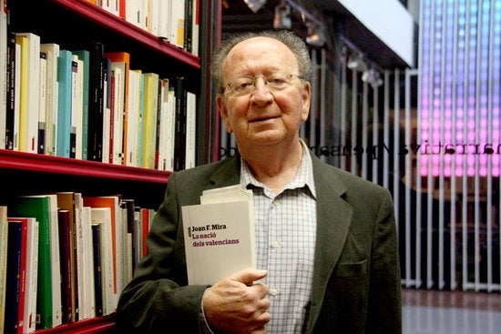 L'escriptor Joan Francesc Mira posa amb el llibre 'La nació dels valencians' a la llibreria del centre Octubre de València.