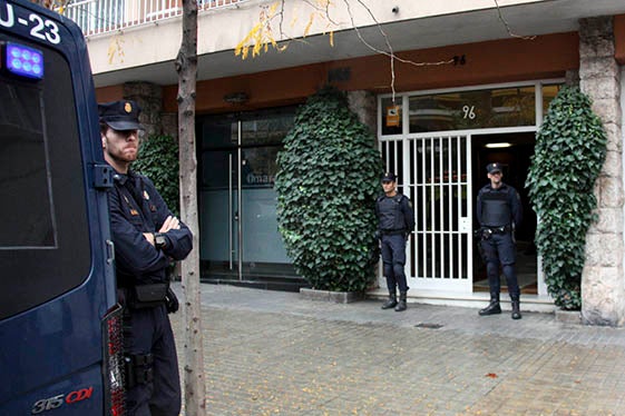 Tres agents de la policia espanyola custodien l'entrada de l'edifici on viu l'expresident de la Generalitat Jordi Pujol.