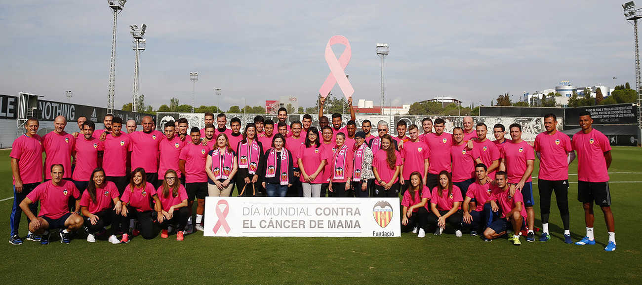 Els components del València masculí i femení dónen suport a la causa abans de l'entrenament.