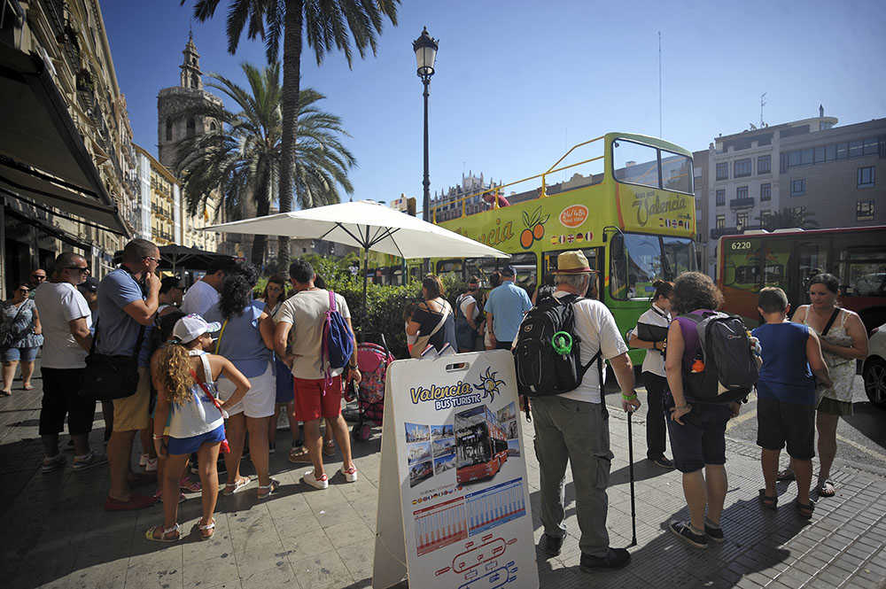 Parada d'un autobús turístic a la plaça de la Reina de València.