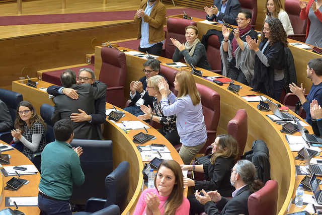 Els grups del govern es feliciten per haver impedit la retirada de la llei d'acompanyament mentre s'abracen el síndic del PSPV, Manolo Mata i el conseller Vicent Soler.