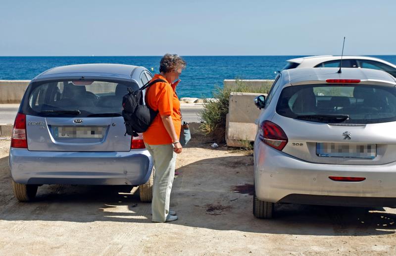 Una dona observa la taca de sang en el lloc on van ocórrer els fets, a l'aparcament alacantí de l'Albufereta.