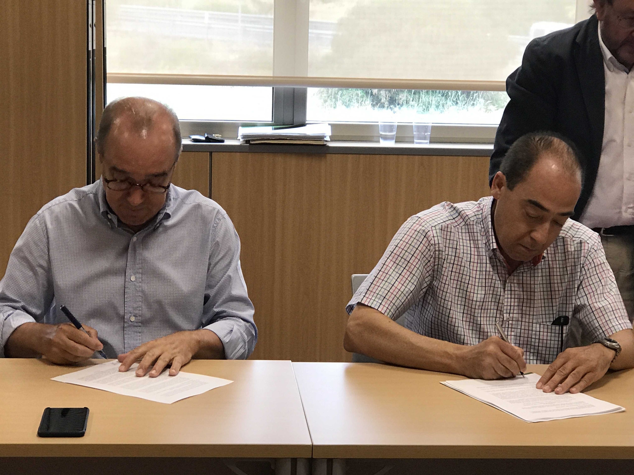 Antoni Mayor, president d'Hosbec, i Manuel Ramón, representant d'UGT PV, signen el conveni col·lectiu d'hostaleria