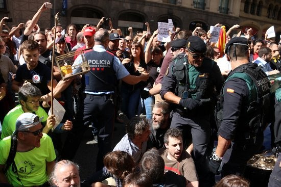 Agents dels Mossos d'Esquadra i de la Guàrdia Civil entre manifestants en un dels escorcolls per l'operació contra el referèndum a la Via Laietana de Barcelona.