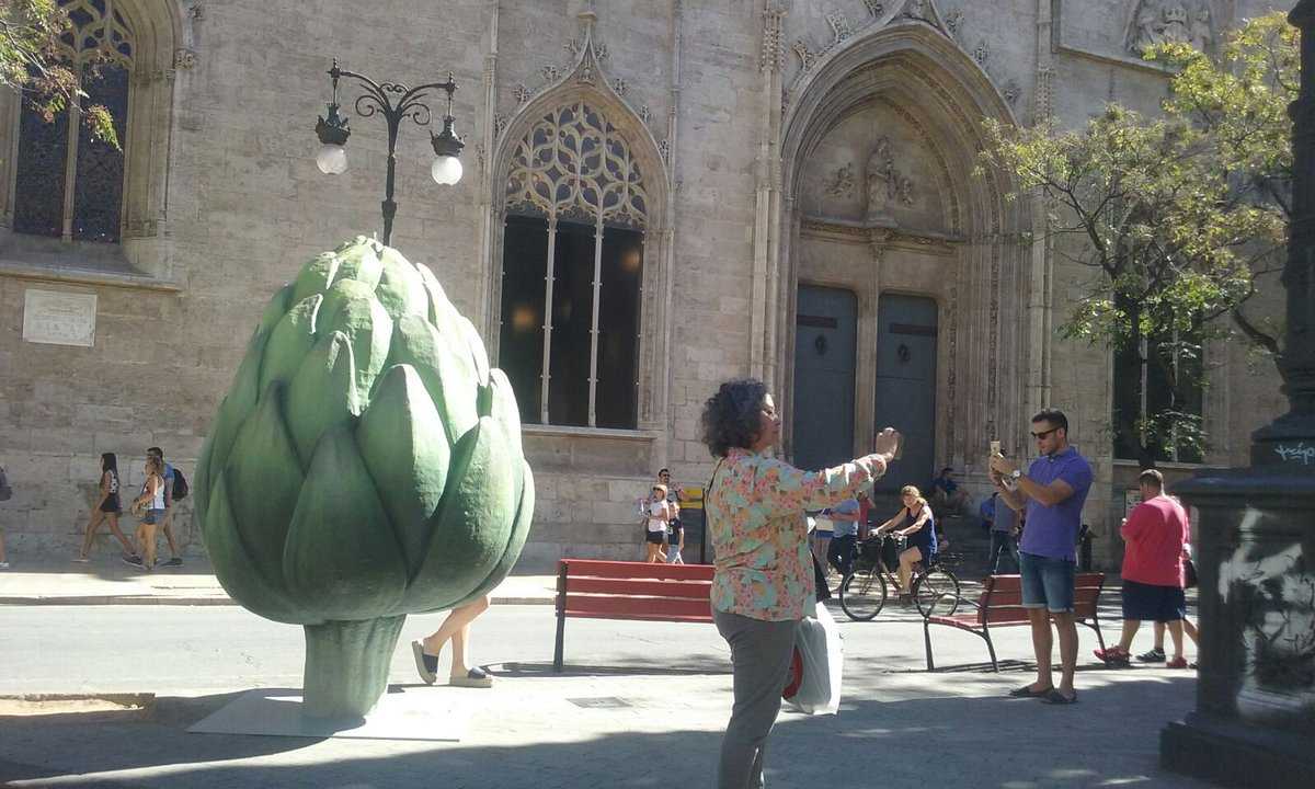 Entre altres verdures i fruites gegants, recorrent els carrers del centre de València es pot trobar una carxofa davant la Llotja.
