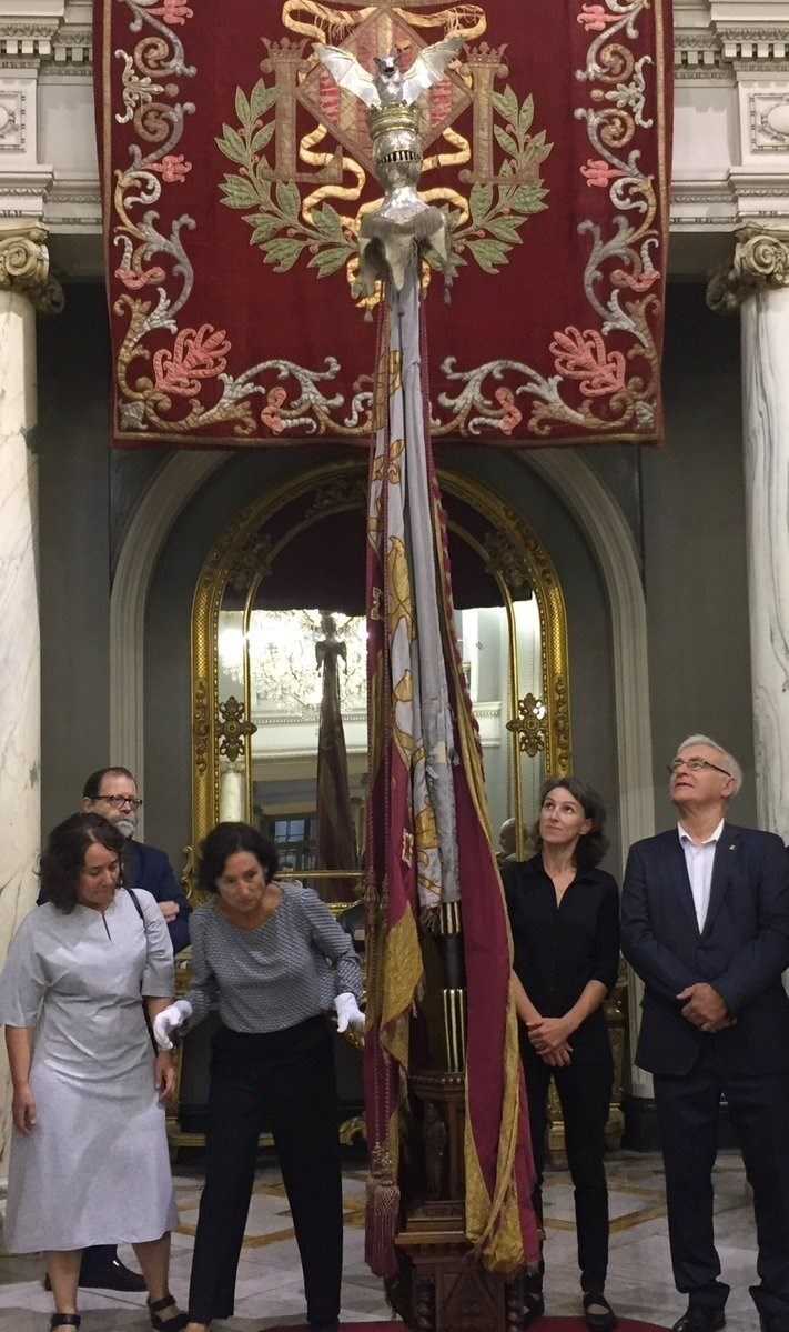Joan Ribó i les regidores Glòria Tello i Maria Oliver observen la Reial Senyera.