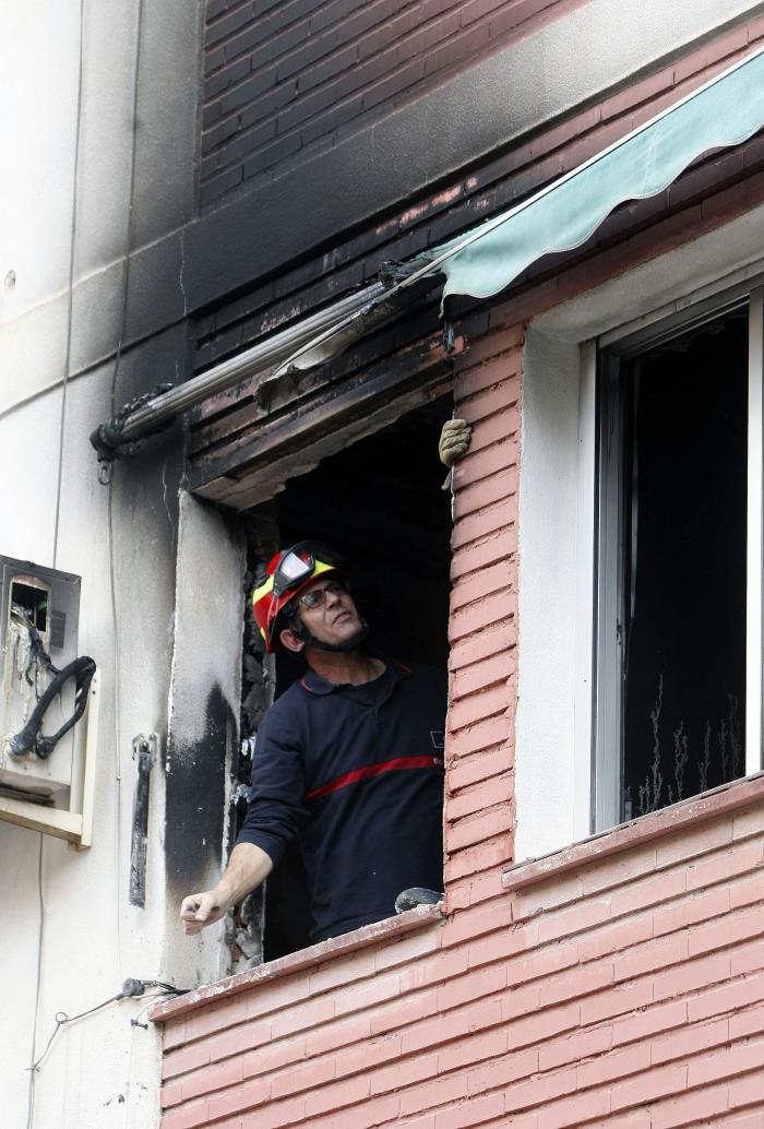 Un bomber inspecciona un habitatge en què s'ha produït un incendi. / EFE