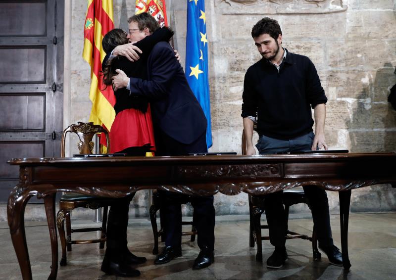 El president de la Generalitat, Ximo Puig, i la vicepresidenta, Mónica Oltra, s'abracen al costat del líder de Podem, Antonio Estañ, en una reunió. Imatge d'arxiu. / EFE