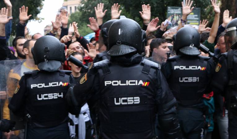 Agents de la Policia Nacional, impedint l'accés de ciutadans que feien cua per a votar a l'Institut Ramon Llull, a Barcelona. Imatge d'arxiu.