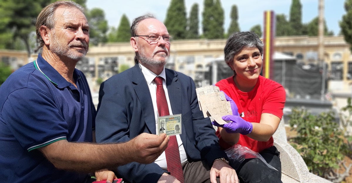 Els nets de Francisco Sanz Herráez, al costat de l'arqueòloga que va localitzar les postals entre les restes d'aquest represaliat pel franquisme enterrat en la fossa comuna 127 del cementeri de Paterna. / EUROPA PRESS