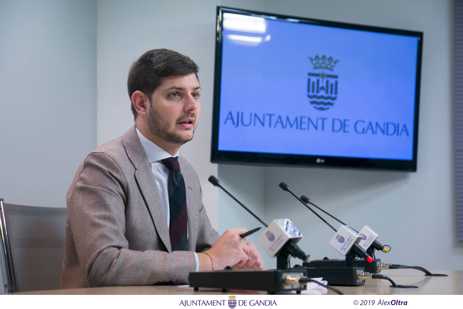 El regidor Jose Manuel Prieto ha comparegut aquest matí en roda de premsa per a informar sobre la iniciativa, que pretén reivindicar un element fonamental de les festes com és la cartelleria.  / AJUNTAMENT DE GANDIA, ÀLEX OLTRA