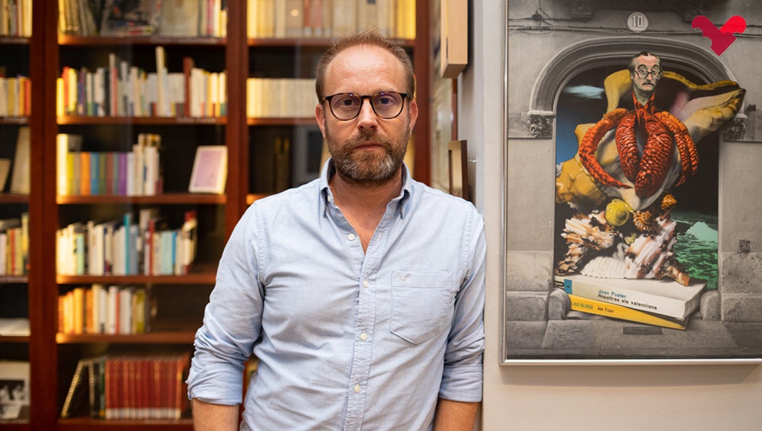 Voro Ortells a l'Espai Joan Fuster, al costat d'una obra de Josep Renau