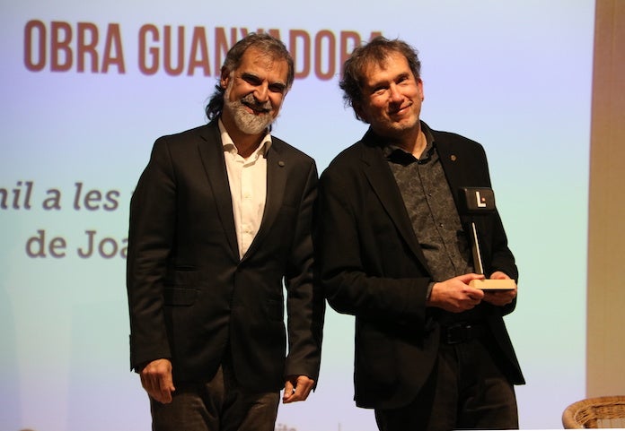 El president d'Òmnium, Jordi Cuixart, amb el guanyador del cinquè Premi Òmnium a la Millor Novel·la de l'Any, Joan Lluís-Lluís, a la llibreria Ona | Pau Cortina | Violeta Gumà | ACN