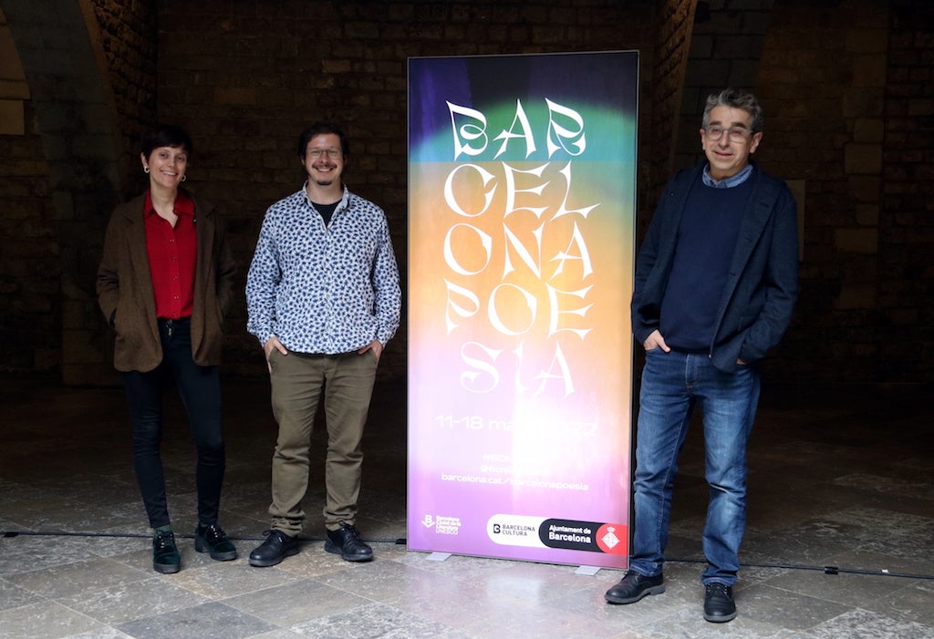 Els co-comissaris del Barcelona Poesia 2022, Maria Callís i Josep Pedrals, i el Tinent d'alcaldia de Cultura, Jordi Martí, amb el cartell de l'edició | Pau Cortina | ACN
