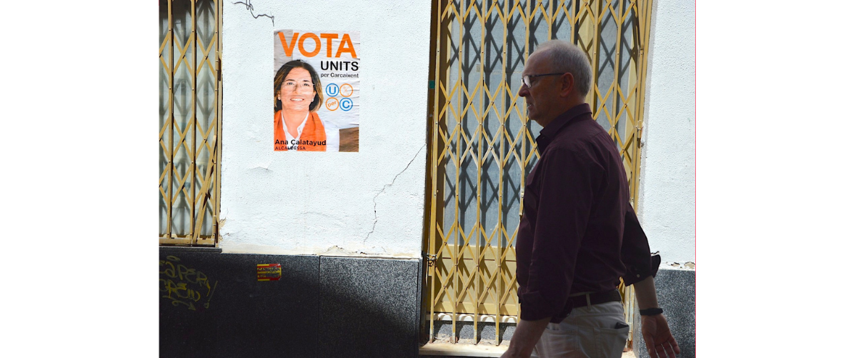 L'alcalde de Carcaixent, Paco Salom, passant per davant d'un cartell electoral d'Units | Sergi Moyano