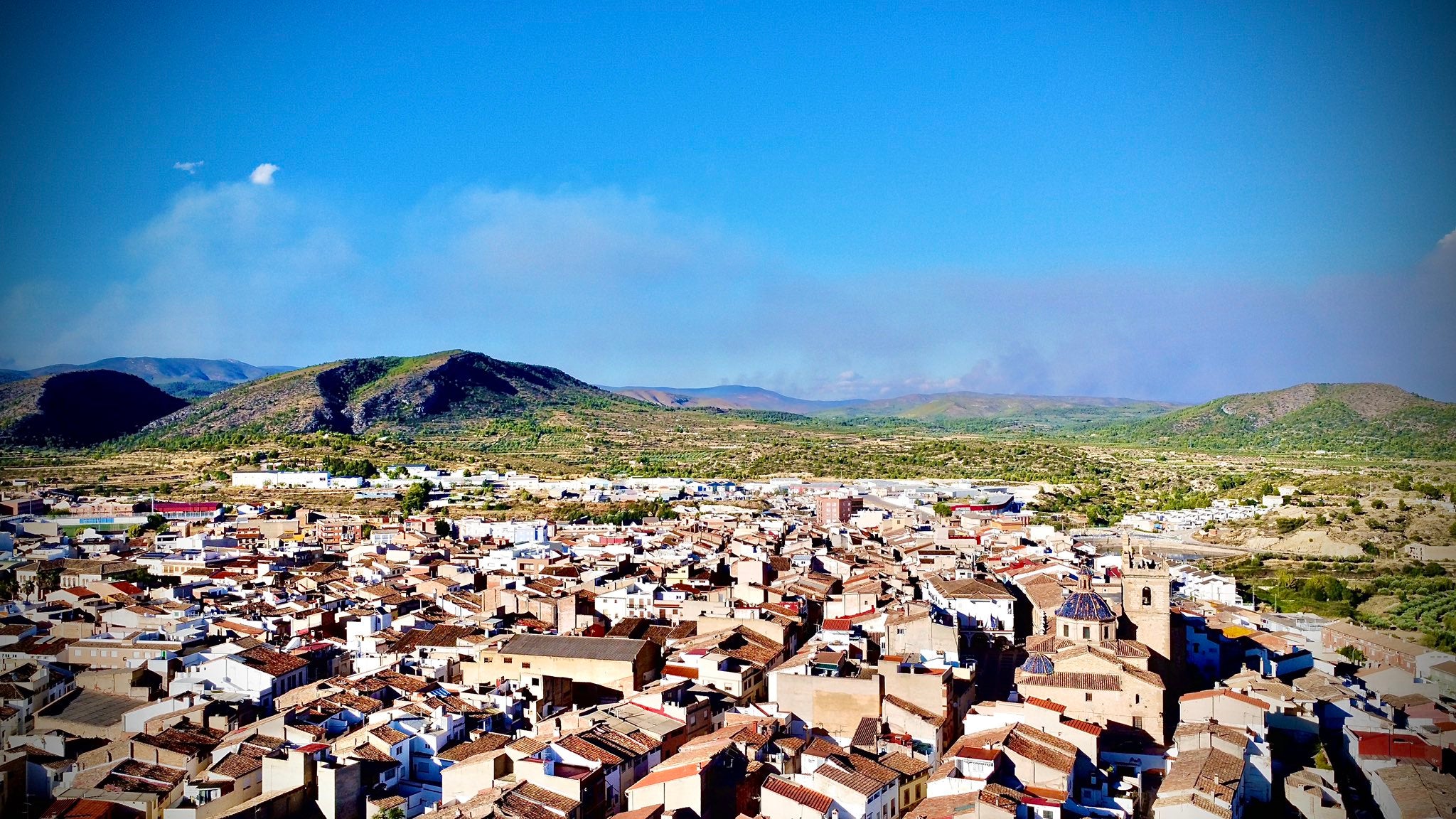 Vista aèrea del Villar, amb el fum de l'incendi de l'Alt Palància al fons