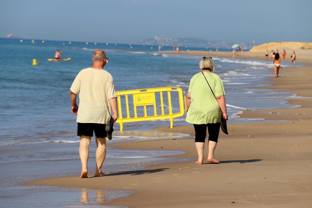 Dues persones passejant per la platja | ACN