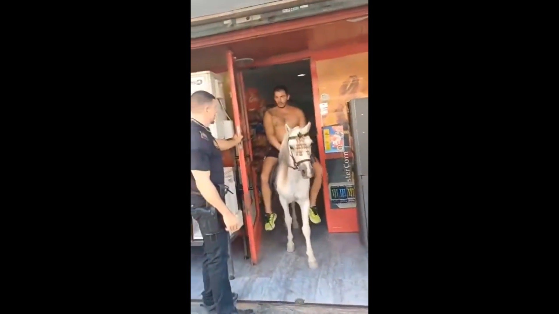 Captura del vídeo emès per TeleElx amb un home a cavall eixint d'un supermercat