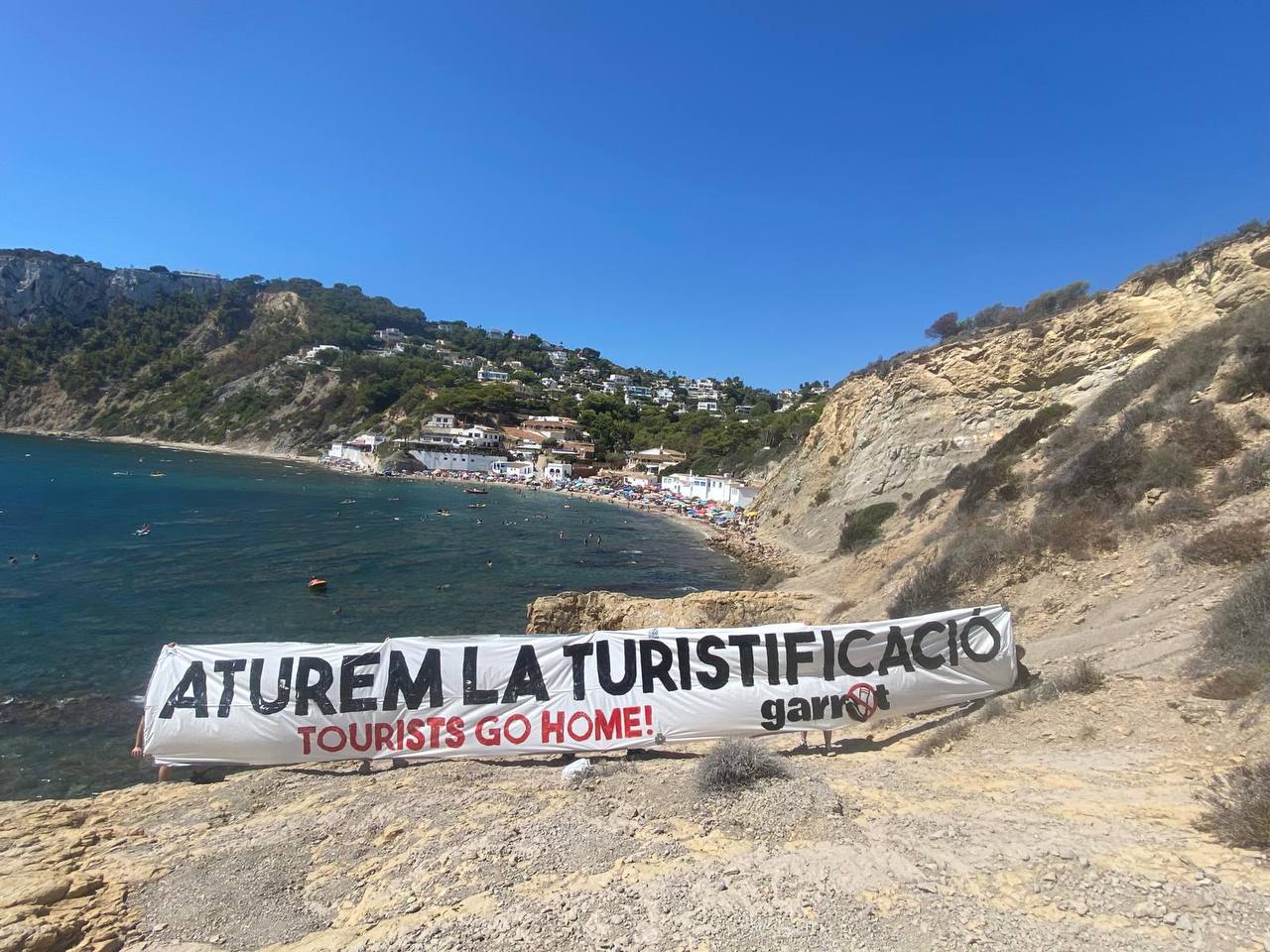 El Col·lectiu Garrot ha desplegat una pancarta contra el turisme massiu a Xàbia