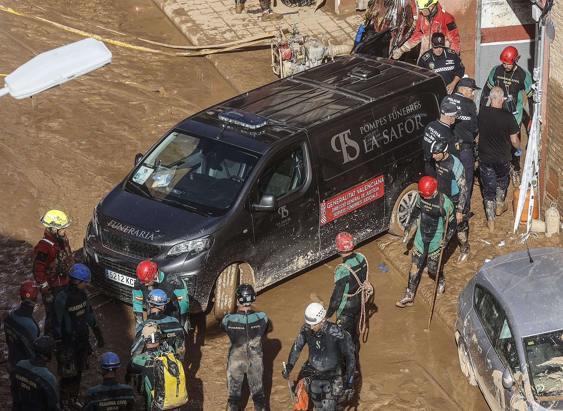 Un furgó funerari ix d'un garatge amb cadàvers localitzats després del pas de la DANA, al barri de la Torre de València | Rober Solsona | EP