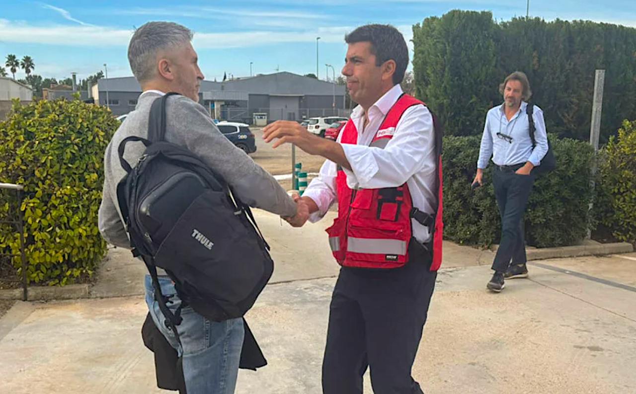 El president valencià, Carlos Mazón, se saluda amb el ministre espanyol d'Interior, Fernando Grande-Marlaska, amb el seu cap de gabinet José Manuel Cuenca de fons / Ministeri d'Interior