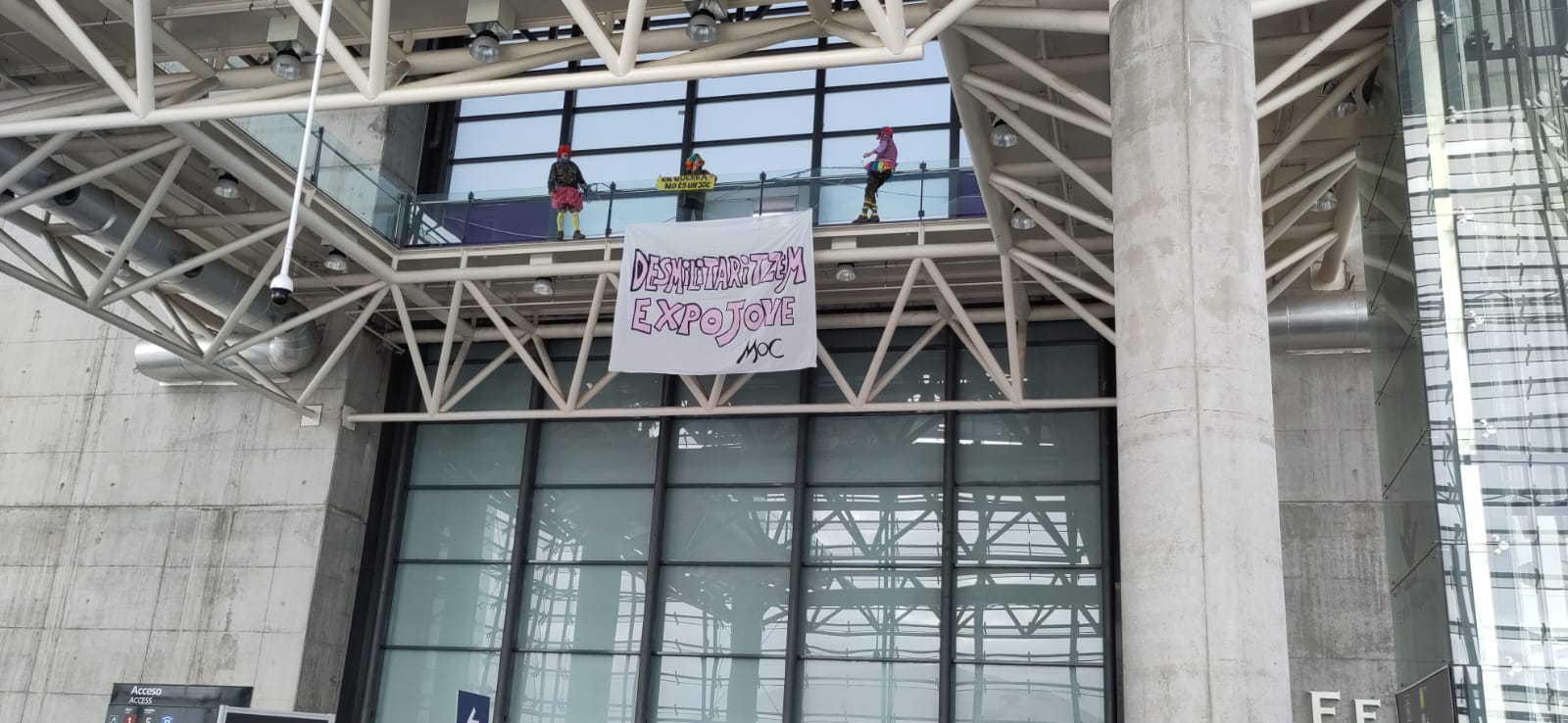 Els antimilitaristes amb la pancarta a la inuaguració oficial de l'Expojove