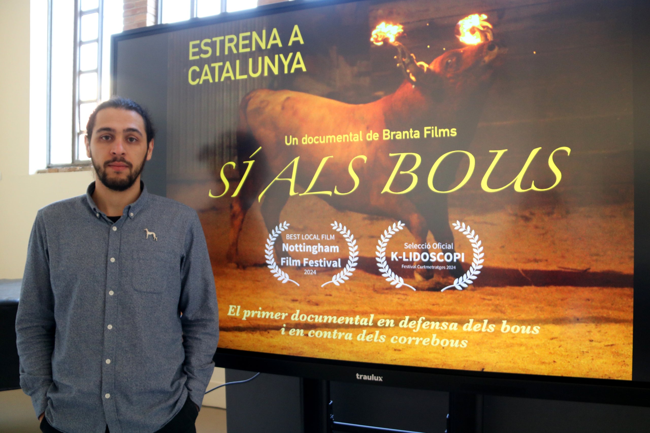El director i fundador de Branta Films, Jusep Moreno, al costat del cartell del documental «Sí als bous» | Anna Ferràs | ACN