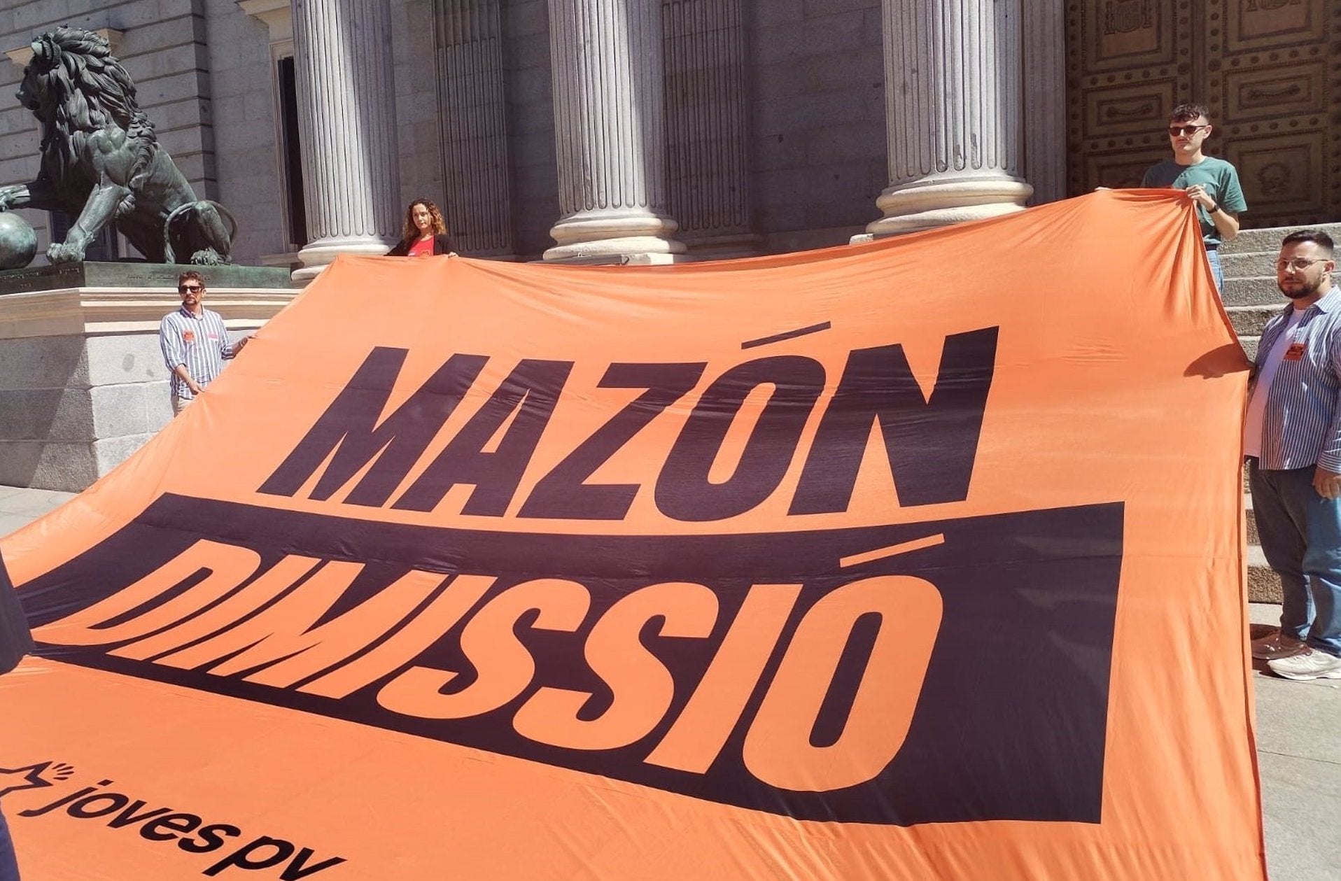 Joves PV - Compromís desplega una pancarta demanant la dimissió de Mazón davant del Congrés