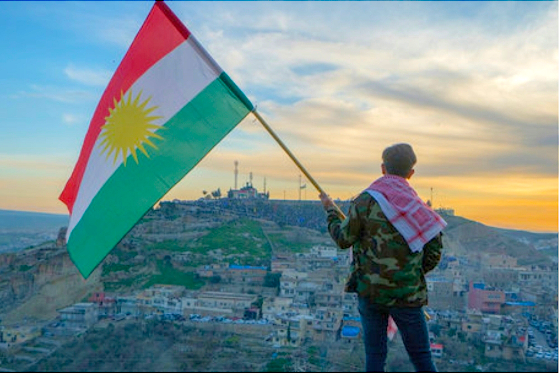 Un home enlaira la bandera del Kurdistan | Adobe Stock