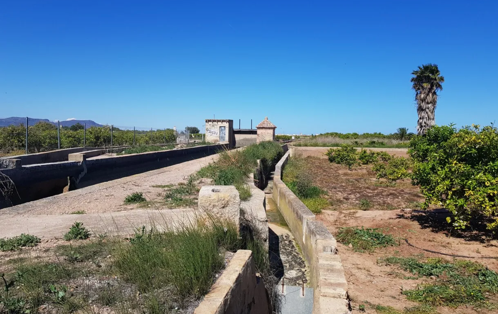 A la dreta de la imatge una part de l’espai que va ocupar l’edifici del motor des de 1911 fins envers 1988. Al fons es pot apreciar el Quadrat que la Reial Séquia de Montcada té al terme municipal d’Albalat dels Sorells.