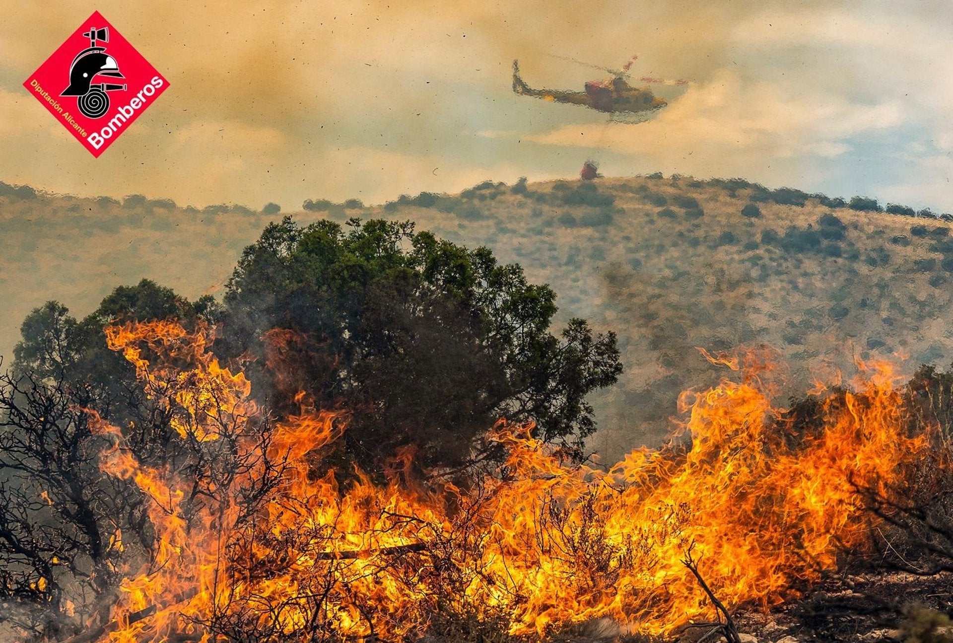 Un helicòpter dels bombers treballa per apagar l'incendi al parc natural de la Font Roja, a finals de juliol