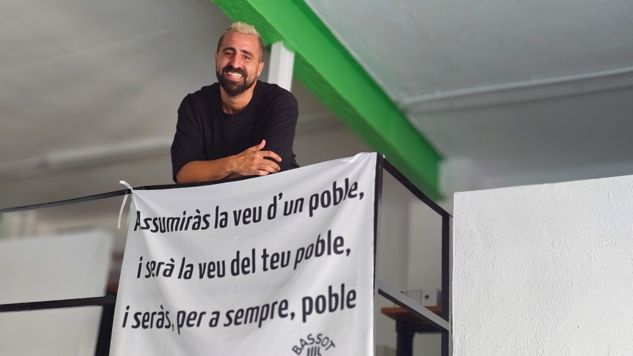 Àrtur cantant de la banda a les oficines de la promotora Pro21 amb la pancarta del centenari del naixement de Vicent Andrés Estellés. Josan Piqueres.