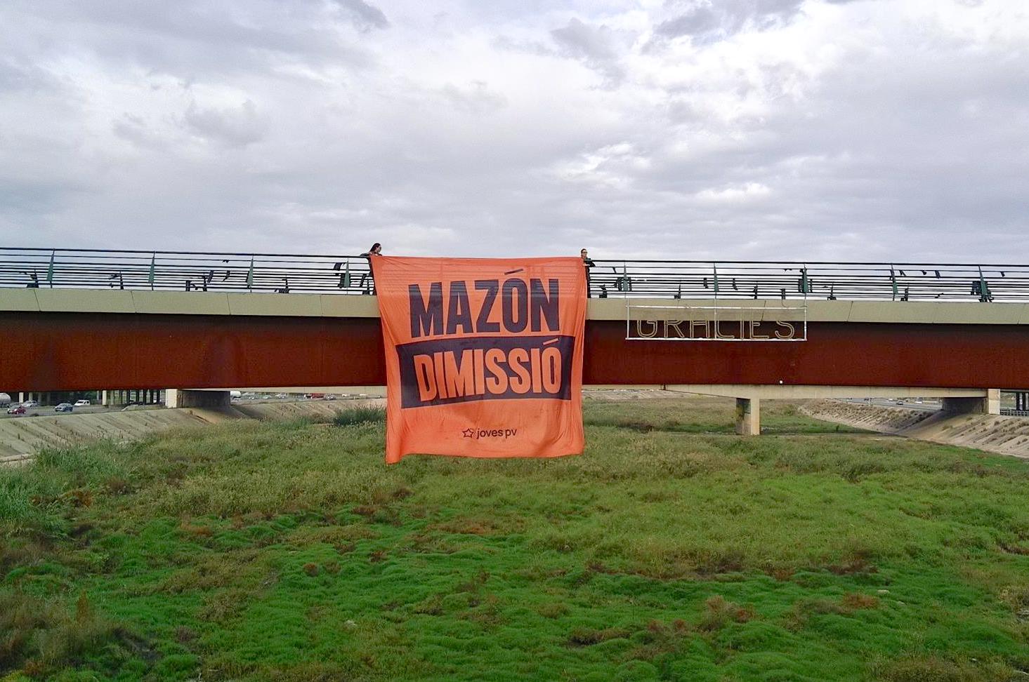 Joves PV penja una gran pancarta de 'Mazón dimissió' al Pont de la Solidaritat en el primer aniversari de la dana