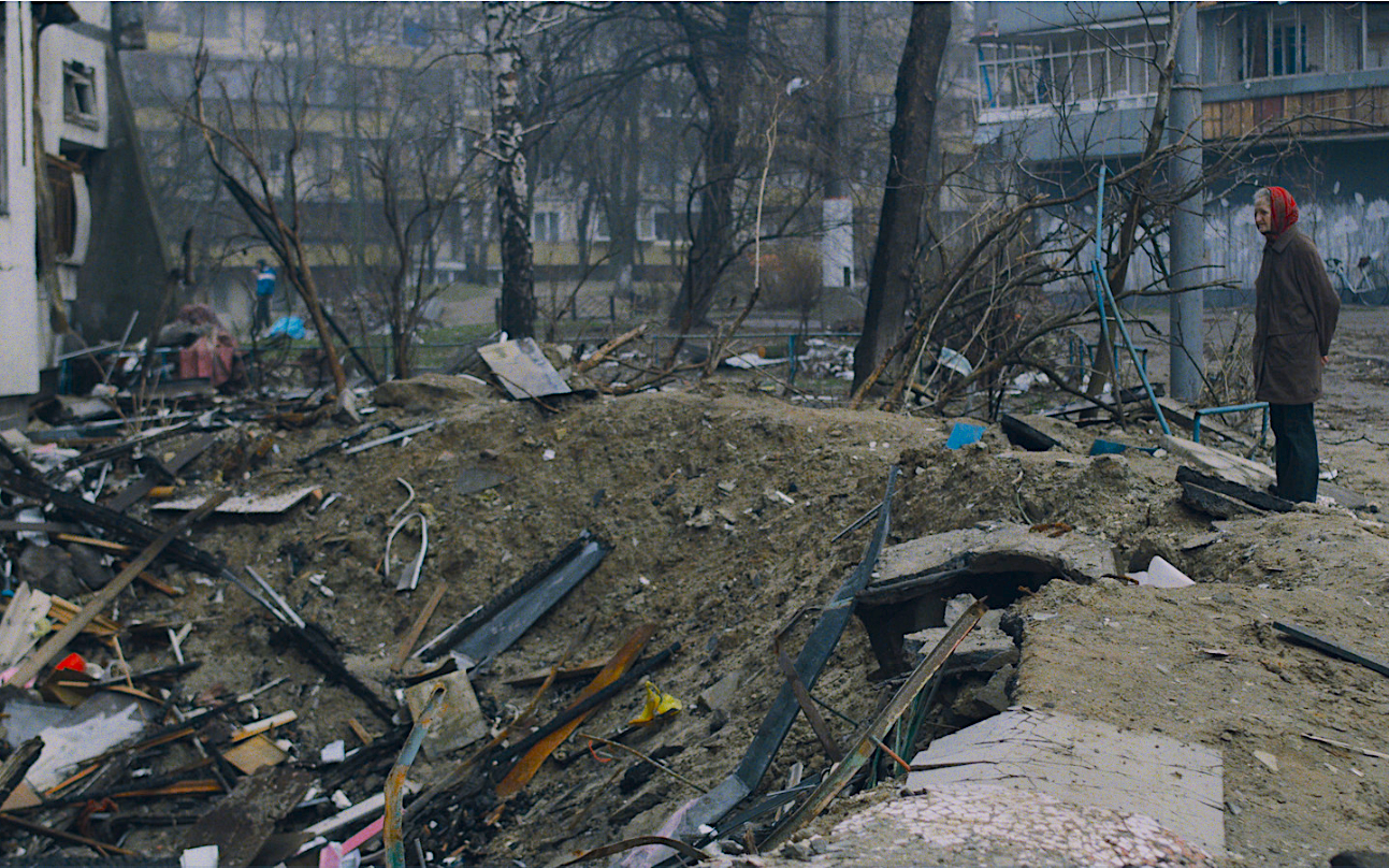 Una dona contempla l'impacte d'una bomba en una ciutat ucraïnesa