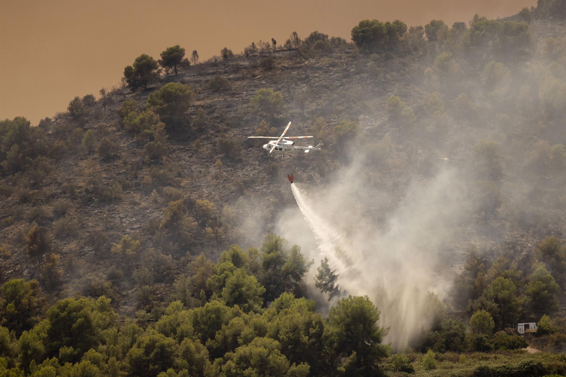 Un helicòpter, durant l’extinció de l'incendi a Betxí. | Carme Ripollés/EP