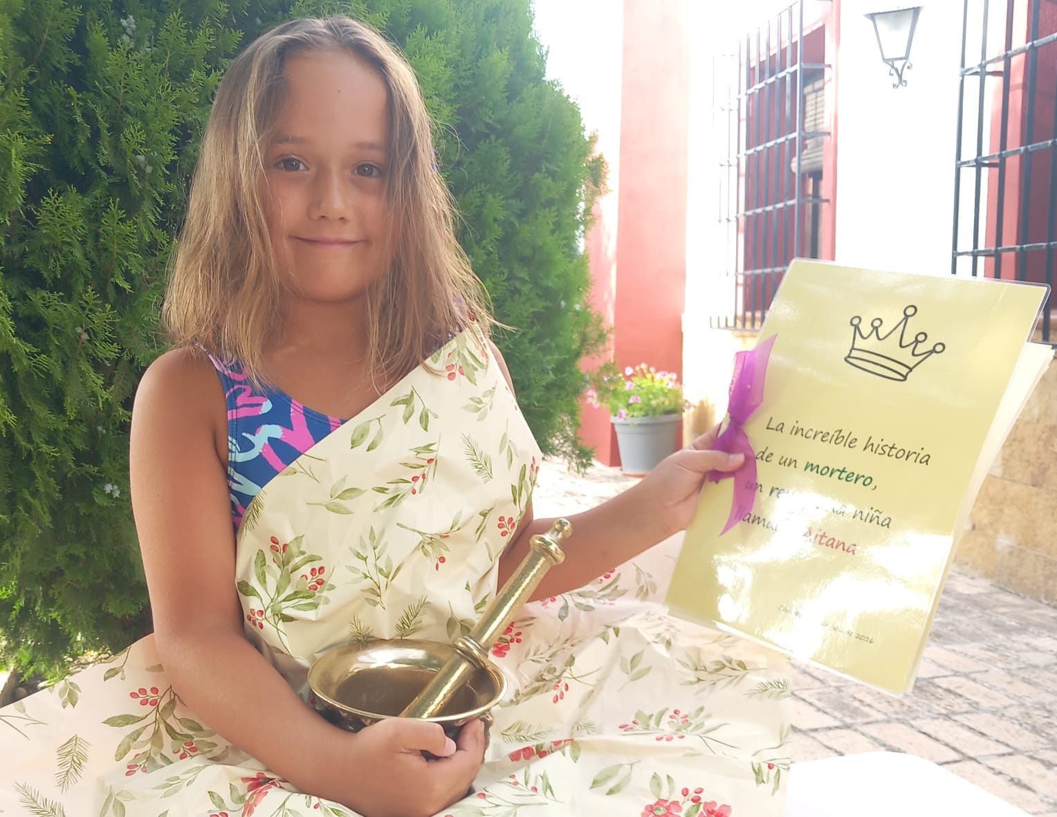 1. Aitana posa amb el morter i el conte escrit per sa tia Alicia on hi ha narrada tota aquest fascinant història.