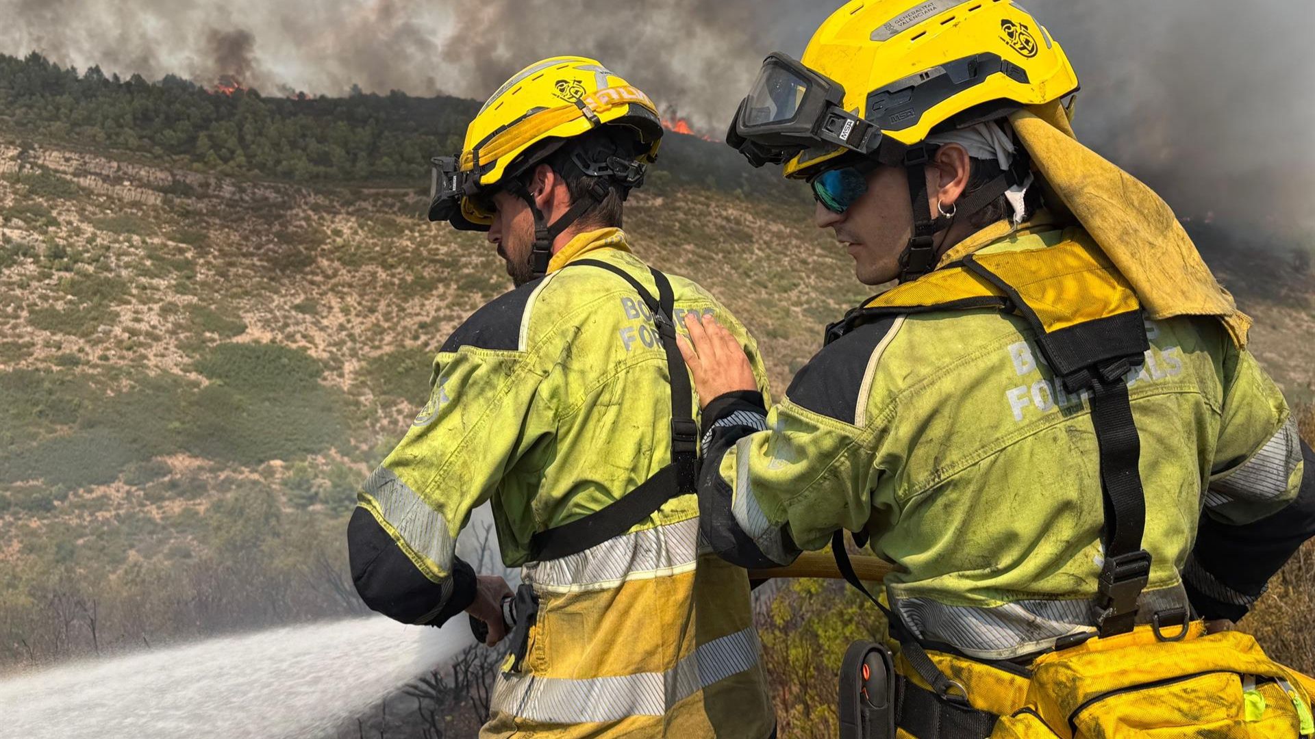 Dos bombers amb una màniga d'aigua intenten apagar el foc | Diputació de Castelló