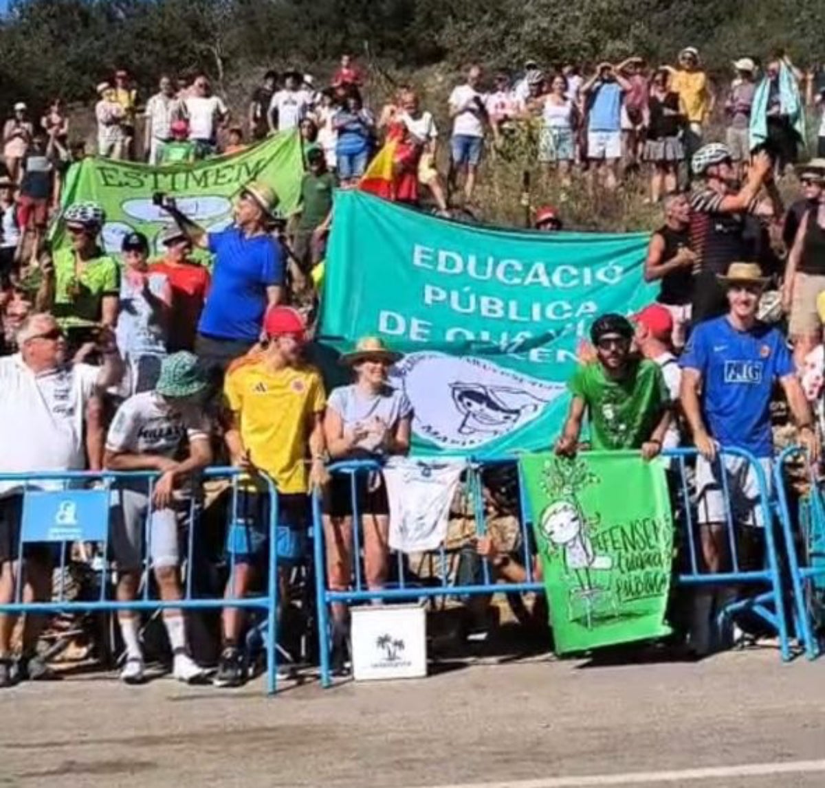 Docents amb pancartes esperant el pas dels ciclistes de La Vuelta