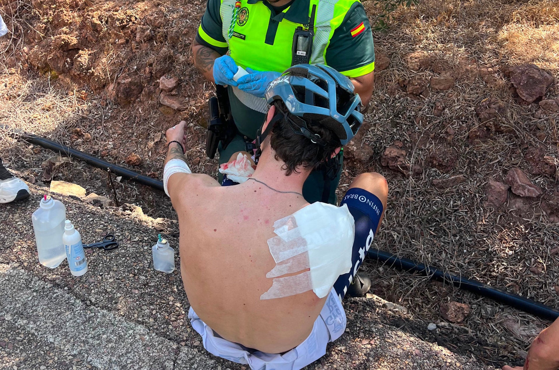 Un agent de la Guàrdia Civil atén un dels ciclistes afectats per una caiguda múltiple en una cursa a Estivella