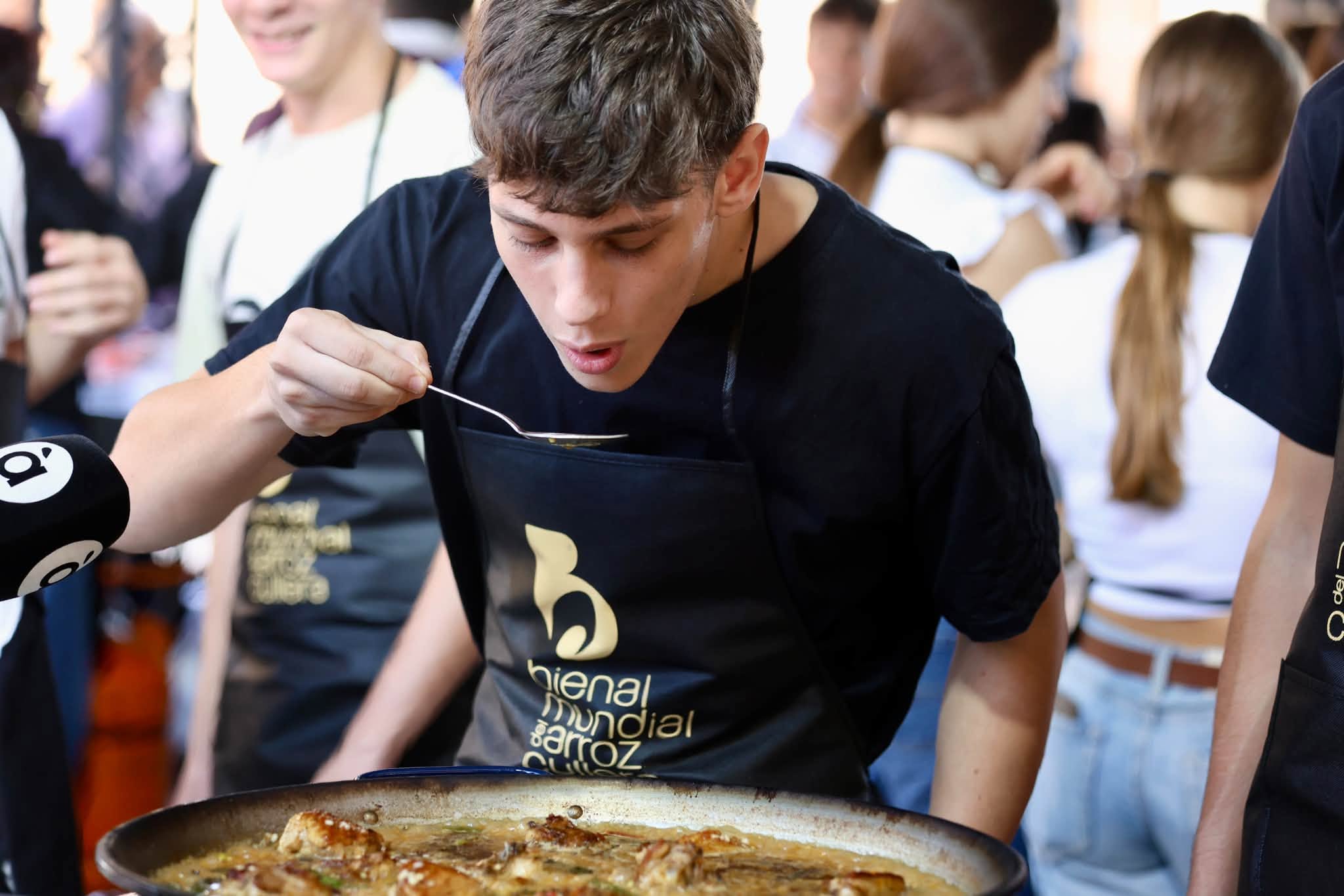 Un dels joves participants fa el típic tast del punt de sal la paella, divendres passat a Cullera.