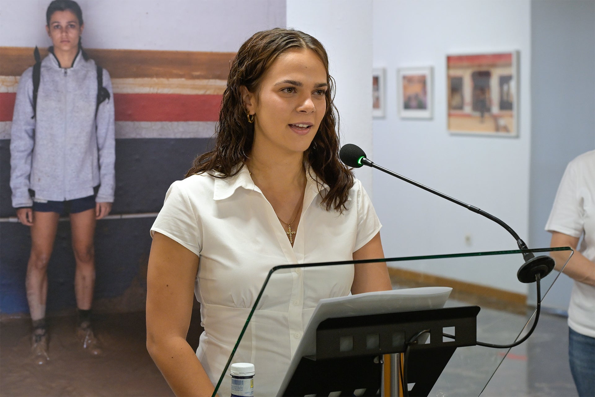 Iris Prieto, en la inauguració. Darrere, foto de gran format d’una voluntària | Ajuntament de Paiporta